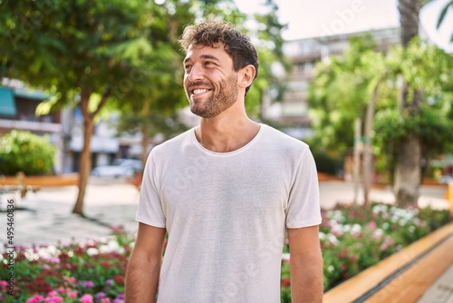 Quadro su tela Young hispanic man smiling confident walking at park