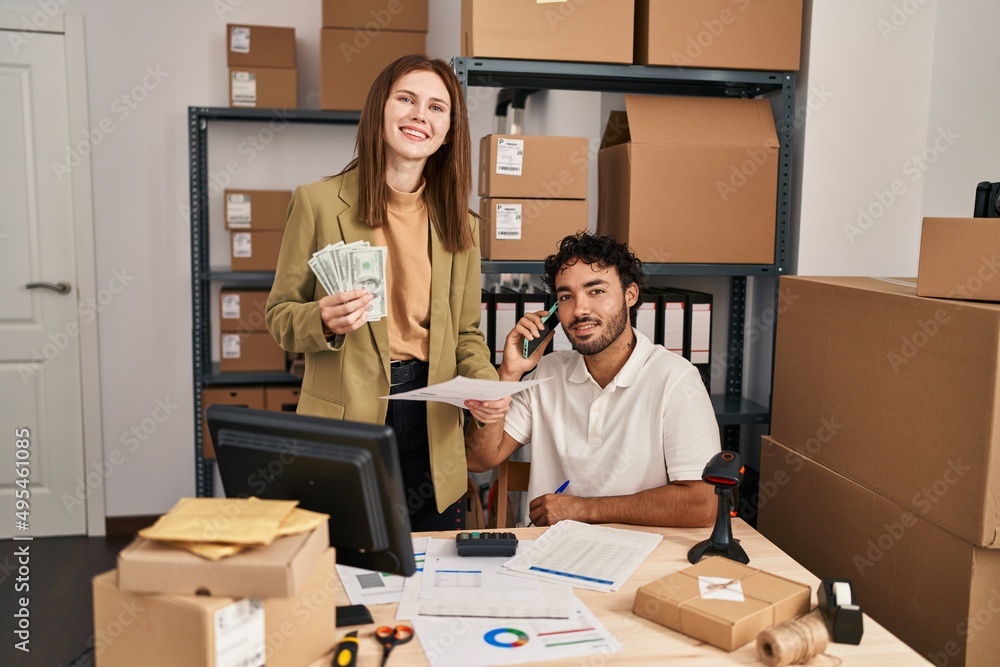 Man and woman business workers talking on the smartphone holding dollars at office Man and woman business workers talking on the smartphone holding dollars at office