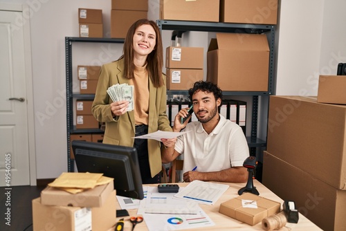 Man and woman business workers talking on the smartphone holding dollars at office © Krakenimages.com