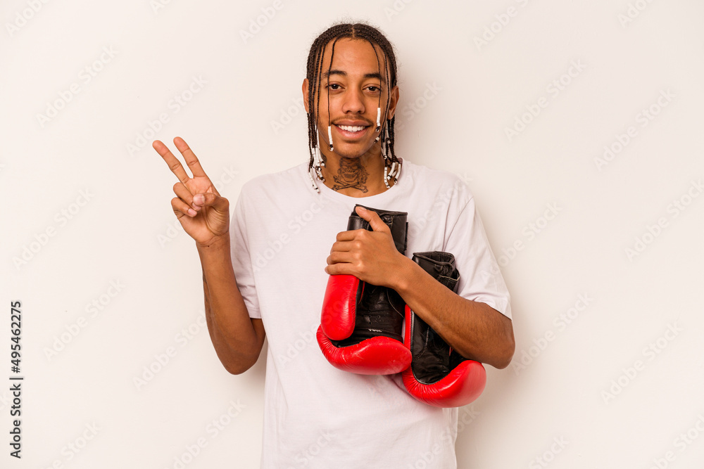 Young African American man playing boxing isolated on white background joyful and carefree showing a peace symbol with fingers. Young African American man playing boxing isolated on white background joyful and carefree showing a peace symbol with fingers.