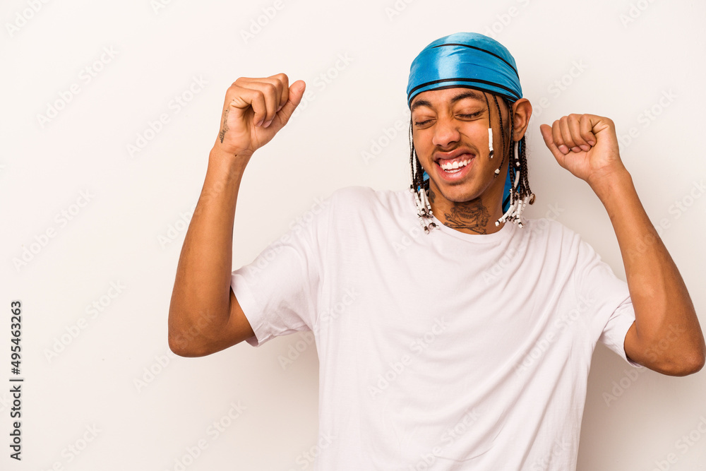 Young African American man isolated on white background raising fist after a victory, winner concept. Young African American man isolated on white background raising fist after a victory, winner concept.