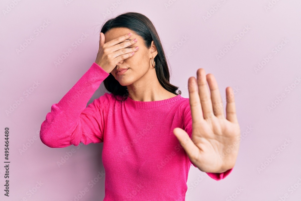 Young hispanic woman wearing casual clothes covering eyes with hands and doing stop gesture with sad and fear expression. embarrassed and negative concept. Young hispanic woman wearing casual clothes covering eyes with hands and doing stop gesture with sad and fear expression. embarrassed and negative concept.