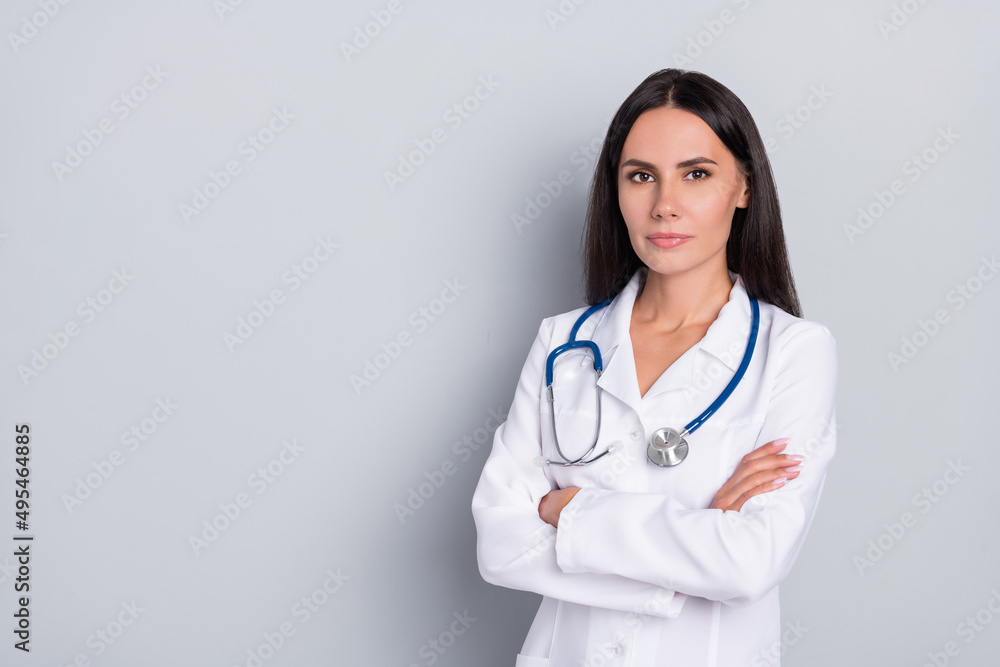 Photo of calm surgeon focused lady folded arms empty space banner isolated on grey color background Photo of calm surgeon focused lady folded arms empty space banner isolated on grey color background
