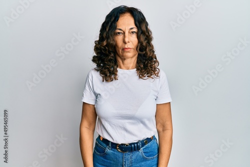 Middle age hispanic woman wearing casual white t shirt skeptic and nervous, frowning upset because of problem. negative person.