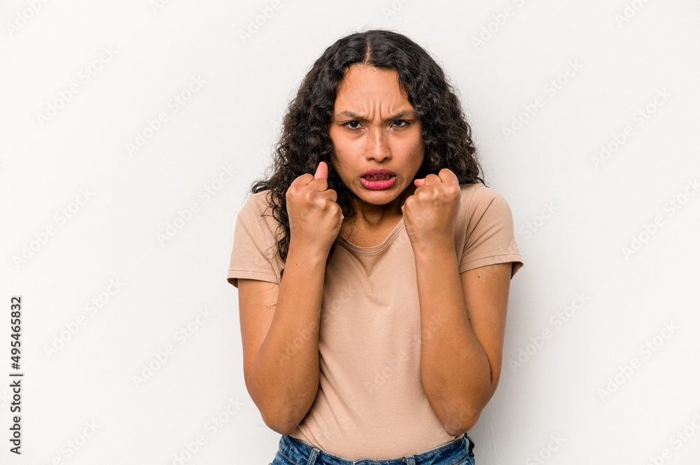 Young hispanic woman isolated on white background showing fist to camera, aggressive facial expression. Young hispanic woman isolated on white background showing fist to camera, aggressive facial expression.
