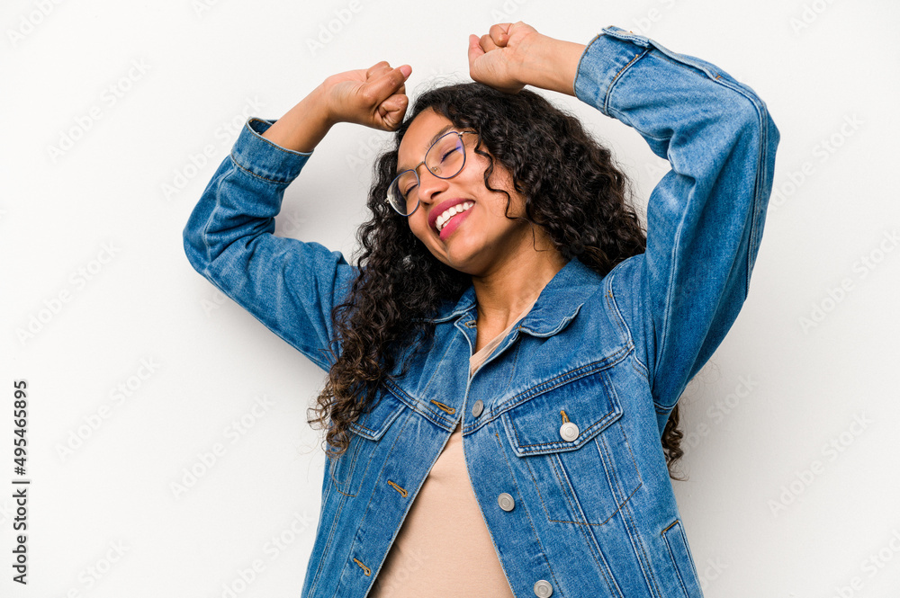 Young hispanic woman isolated on white background celebrating a special day, jumps and raise arms with energy. Young hispanic woman isolated on white background celebrating a special day, jumps and raise arms with energy.