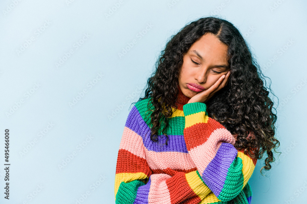 Young hispanic woman isolated on blue background who feels sad and pensive, looking at copy space. Young hispanic woman isolated on blue background who feels sad and pensive, looking at copy space.