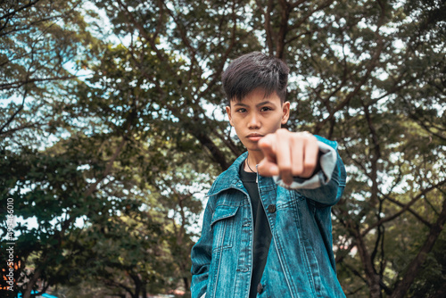 A young serious man in a mad feeling. Pointing a finger to someone. Angry about meddling to his personal problems.