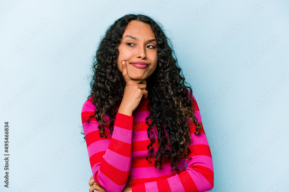 Young hispanic woman isolated on blue background contemplating, planning a strategy, thinking about the way of a business. Young hispanic woman isolated on blue background contemplating, planning a strategy, thinking about the way of a business.