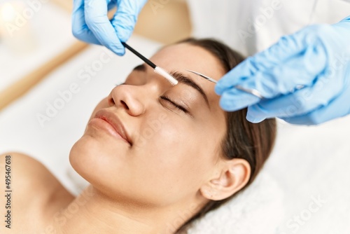 Young latin woman relaxed having eyebrows treatment at beauty center