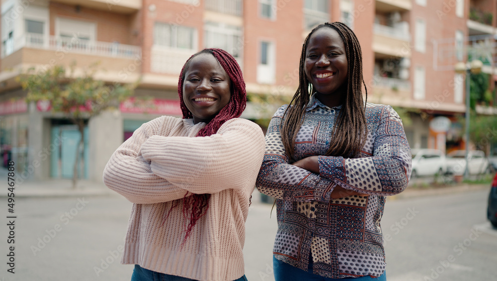 Two african american friends smiling confident standing with arms crossed gesture at street