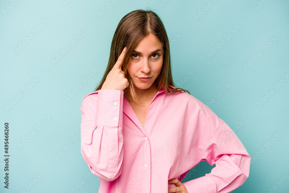 Young caucasian woman isolated on blue background pointing temple with finger, thinking, focused on a task. Young caucasian woman isolated on blue background pointing temple with finger, thinking, focused on a task.