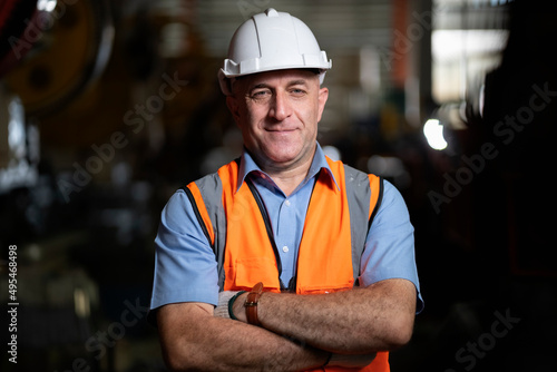 Smart portrait, male senior engineer standing with his arms crossed confidently.