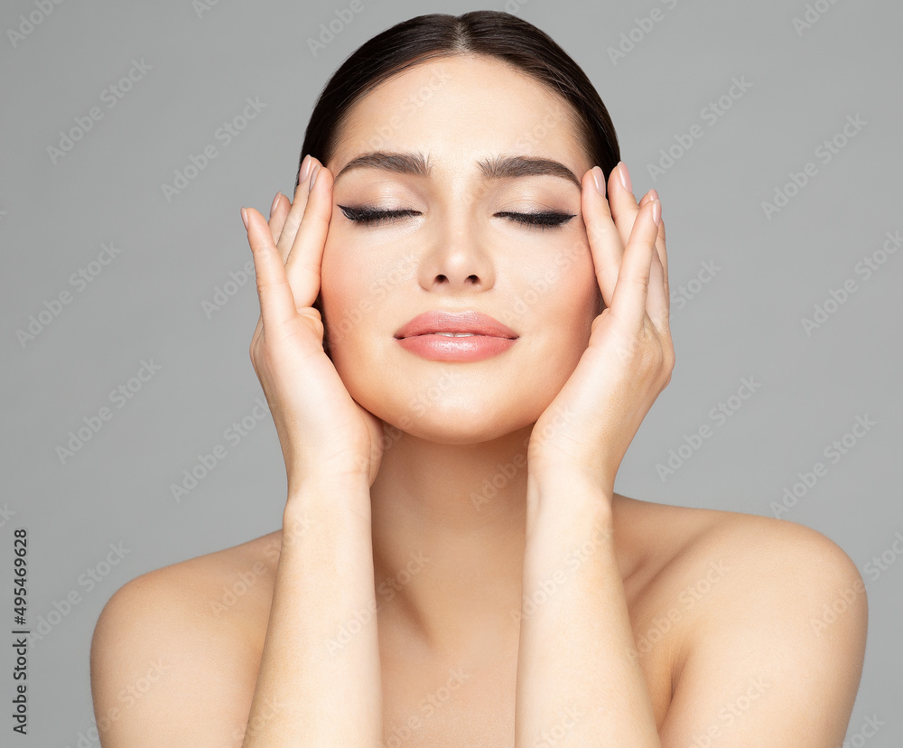 Woman Beauty Face. Women Skin Care and Make up. Model with closed Eyes enjoying Facial Massage. Facelift Cosmetology over Gray. Girl with Plump Lips and Perfect Eyeliner - obrazy, fototapety, plakaty 