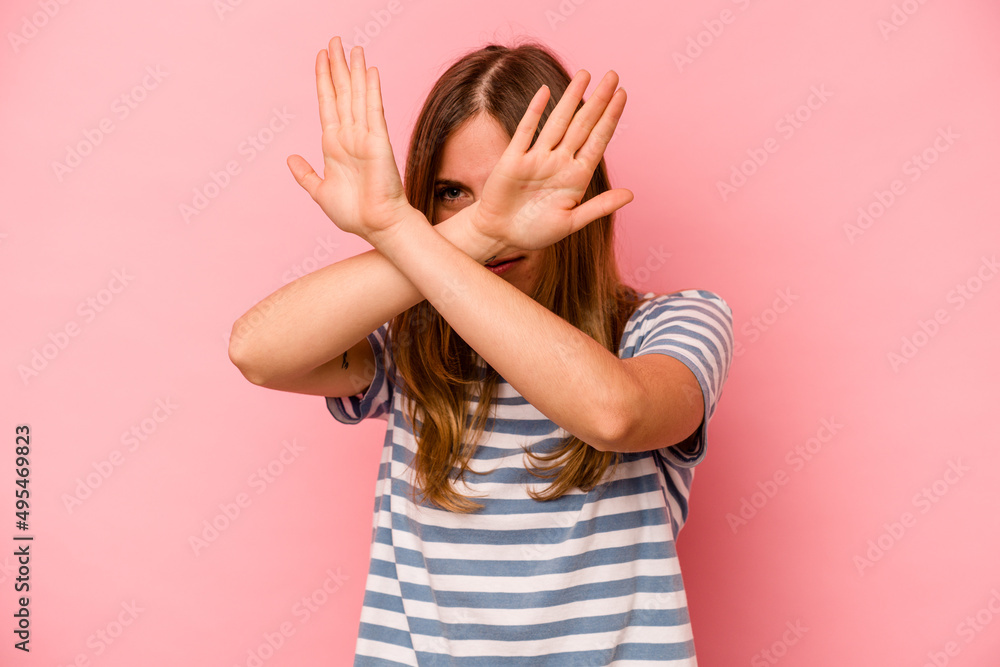 Young caucasian woman isolated on pink background keeping two arms crossed, denial concept. Young caucasian woman isolated on pink background keeping two arms crossed, denial concept.