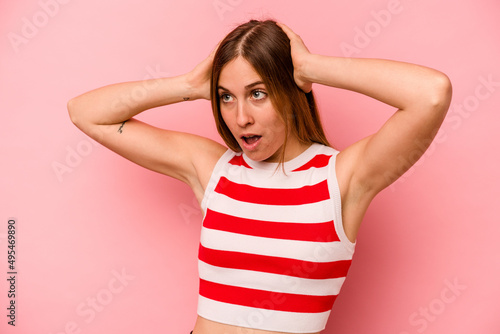 Young caucasian woman isolated on pink background screaming  very excited  passionate  satisfied with something.