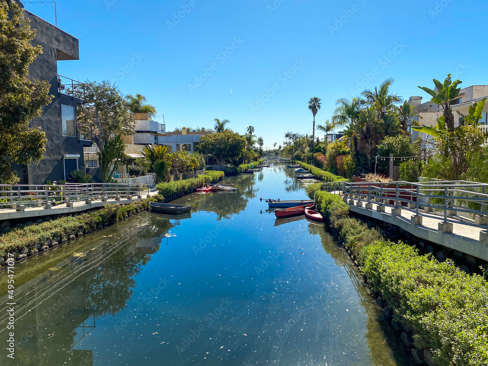 Venice, California: Venice of America Canals in Los Angeles, California. The Venice Canal Historic District man-made wetland canals developed by Abbot Kinney. Grand Canal with boats, palm trees.