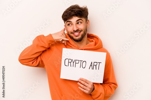 Young hispanic man holding a crypto art placard isolated on white background showing a mobile phone call gesture with fingers.