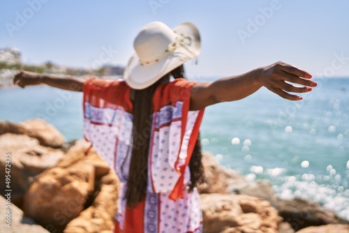 Young african american woman on back view breathing at the beach.