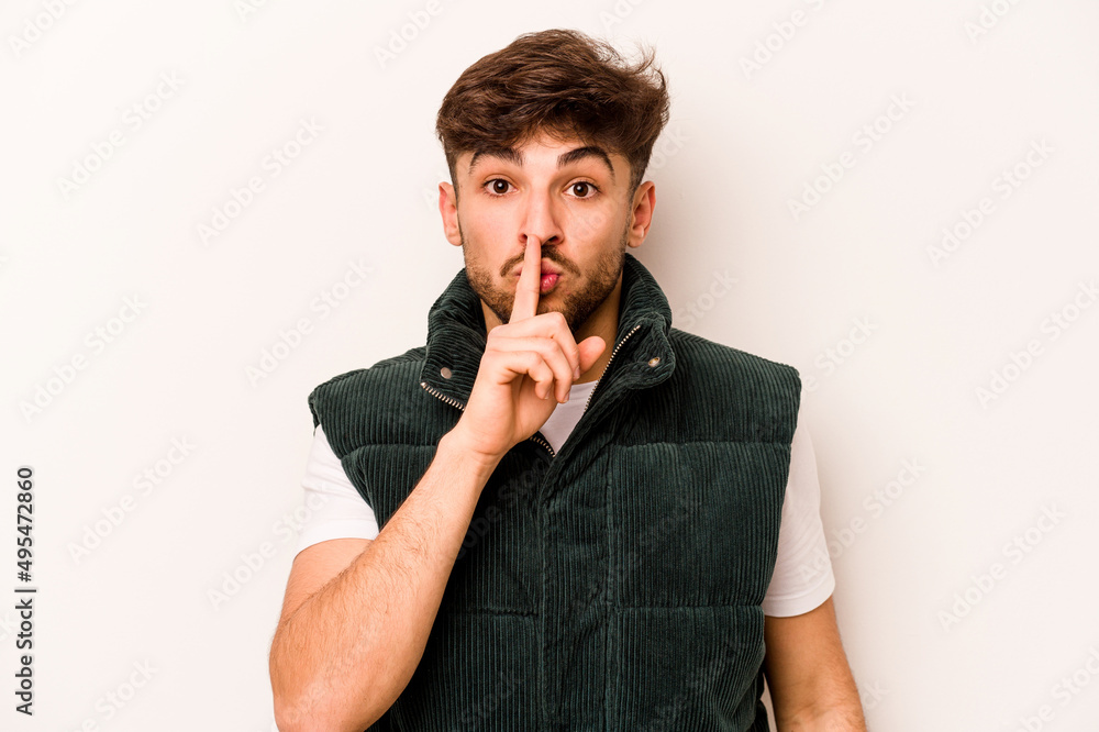 Young hispanic man isolated on white background keeping a secret or asking for silence. Young hispanic man isolated on white background keeping a secret or asking for silence.