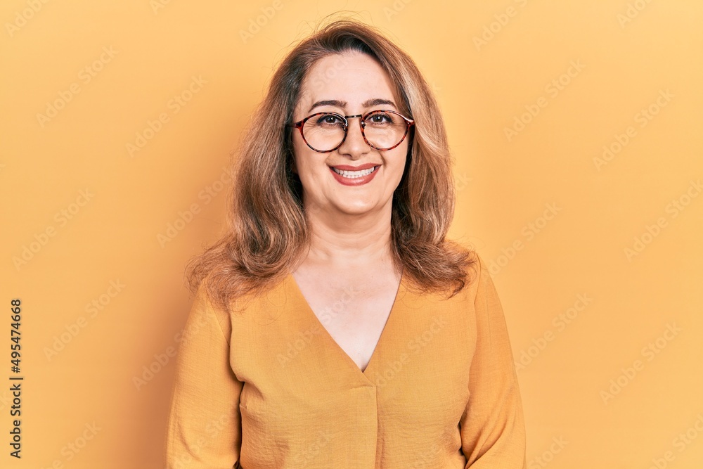 Middle age caucasian woman wearing casual clothes and glasses with a happy and cool smile on face. lucky person.