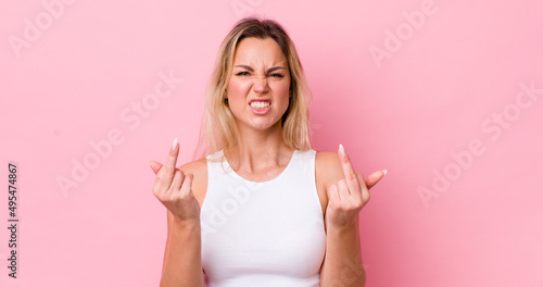 pretty blonde woman feeling provocative, aggressive and obscene, flipping the middle finger, with a rebellious attitude photo