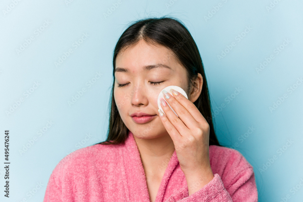 Young asian woman holding a facial disk isolated on pink background Young asian woman holding a facial disk isolated on pink background