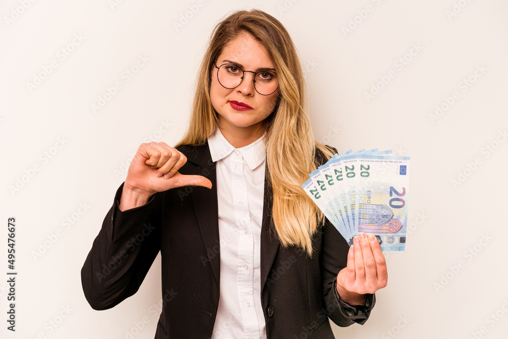 Young business caucasian woman holding a banknotes isolated on white background showing a dislike gesture, thumbs down. Disagreement concept. Young business caucasian woman holding a banknotes isolated on white background showing a dislike gesture, thumbs down. Disagreement concept.