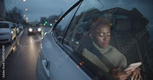 Young Black Business Woman travelling on back seat of uber taxi to get to work