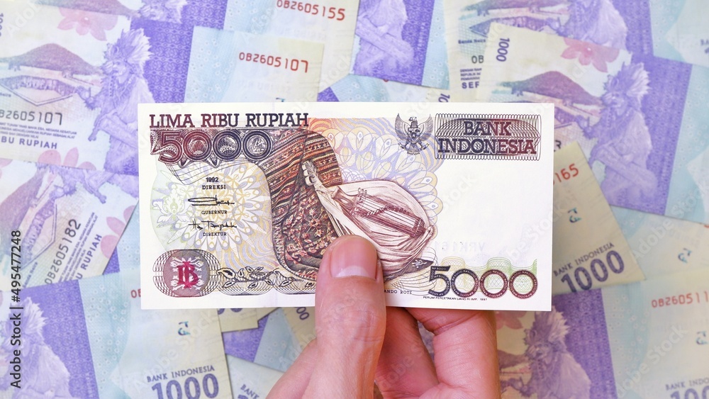 Indonesian Rupiah the official currency of Indonesia. Man's hand is ...