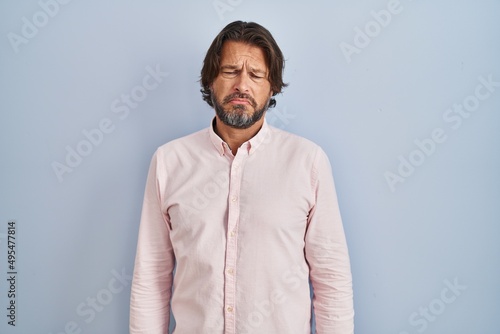 Handsome middle age man wearing elegant shirt background depressed and worry for distress, crying angry and afraid. sad expression.