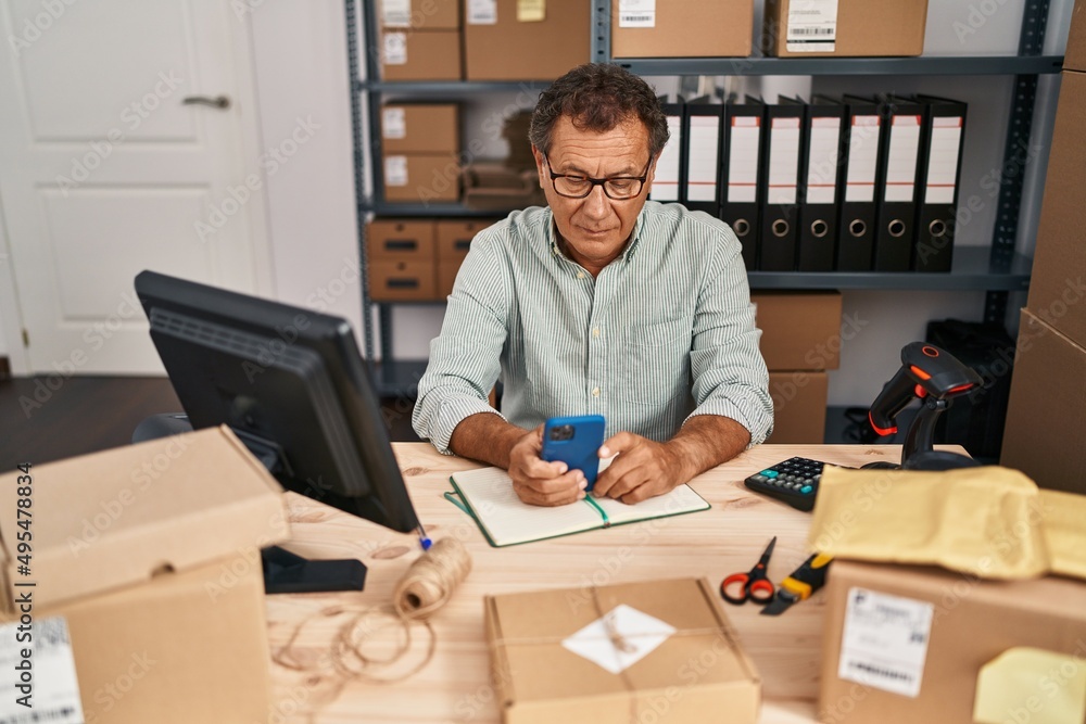 Middle age man ecommerce business worker using smartphone at office Middle age man ecommerce business worker using smartphone at office