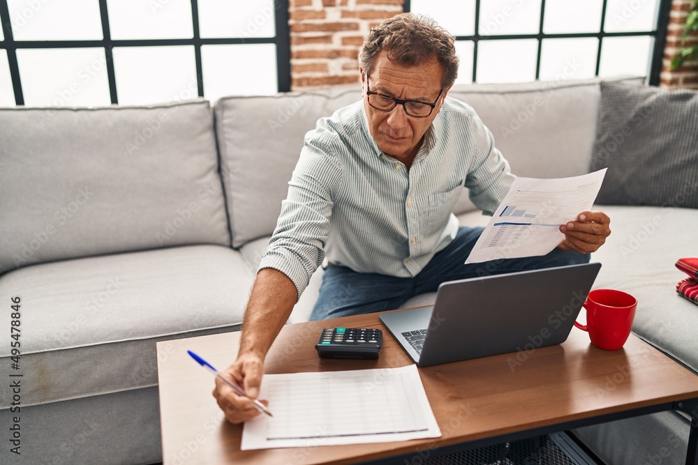 Middle age man working using laptop at home Middle age man working using laptop at home