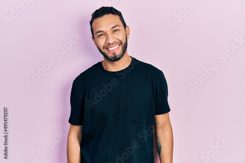 Hispanic man with beard wearing casual black t shirt with a happy and cool smile on face. lucky person.