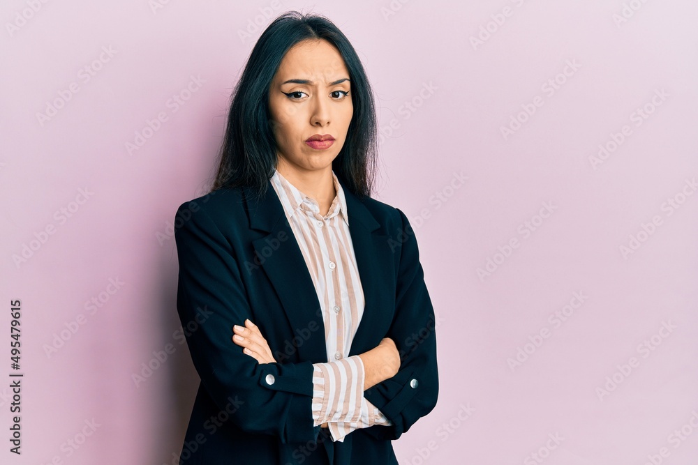 Young hispanic girl wearing business clothes with arms crossed clueless and confused expression. doubt concept. Young hispanic girl wearing business clothes with arms crossed clueless and confused expression. doubt concept.