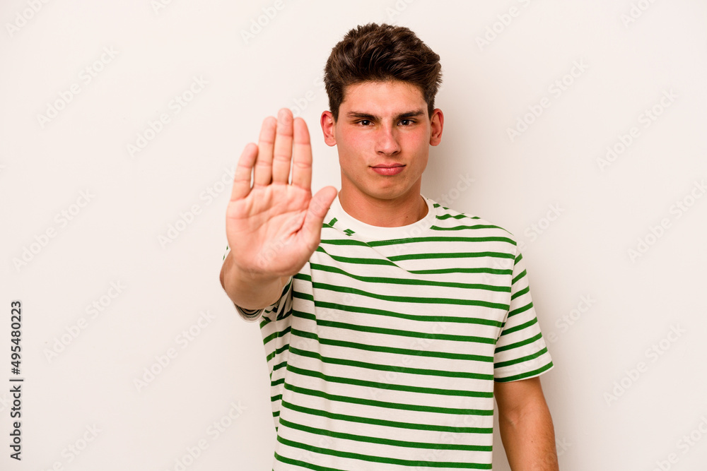 Young caucasian man isolated on white background standing with outstretched hand showing stop sign, preventing you. Young caucasian man isolated on white background standing with outstretched hand showing stop sign, preventing you.