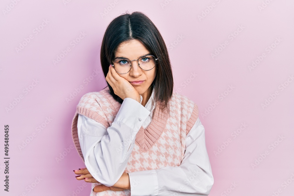 Young brunette woman wearing elegant sweater and glasses thinking looking tired and bored with depression problems with crossed arms. Young brunette woman wearing elegant sweater and glasses thinking looking tired and bored with depression problems with crossed arms.