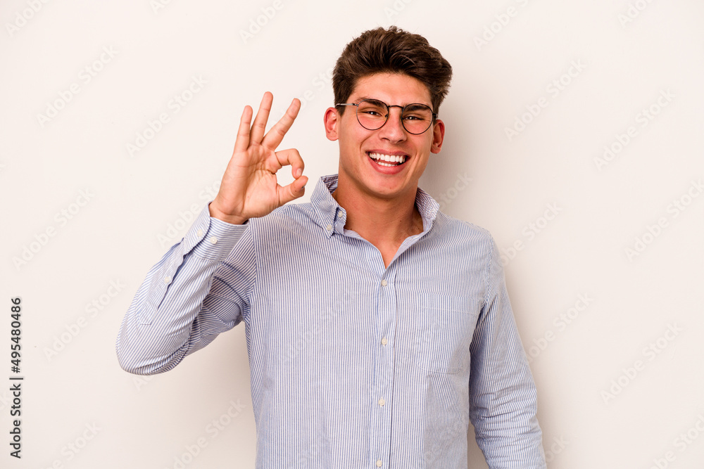 Naklejka premium Young caucasian man isolated on white background cheerful and confident showing ok gesture.