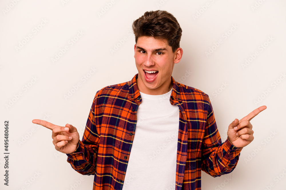 Young caucasian man isolated on white background pointing to different copy spaces, choosing one of them, showing with finger. Young caucasian man isolated on white background pointing to different copy spaces, choosing one of them, showing with finger.