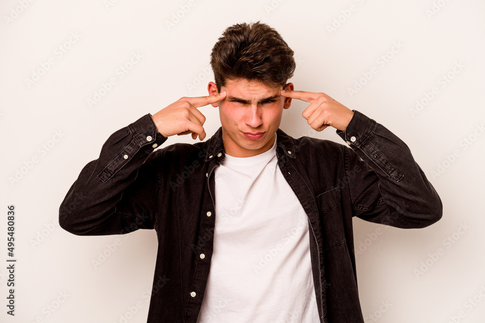 Young caucasian man isolated on white background focused on a task, keeping forefingers pointing head. Young caucasian man isolated on white background focused on a task, keeping forefingers pointing head.