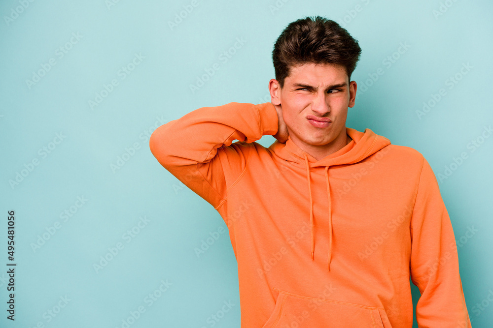 Young caucasian man isolated on blue background touching back of head, thinking and making a choice. Young caucasian man isolated on blue background touching back of head, thinking and making a choice.