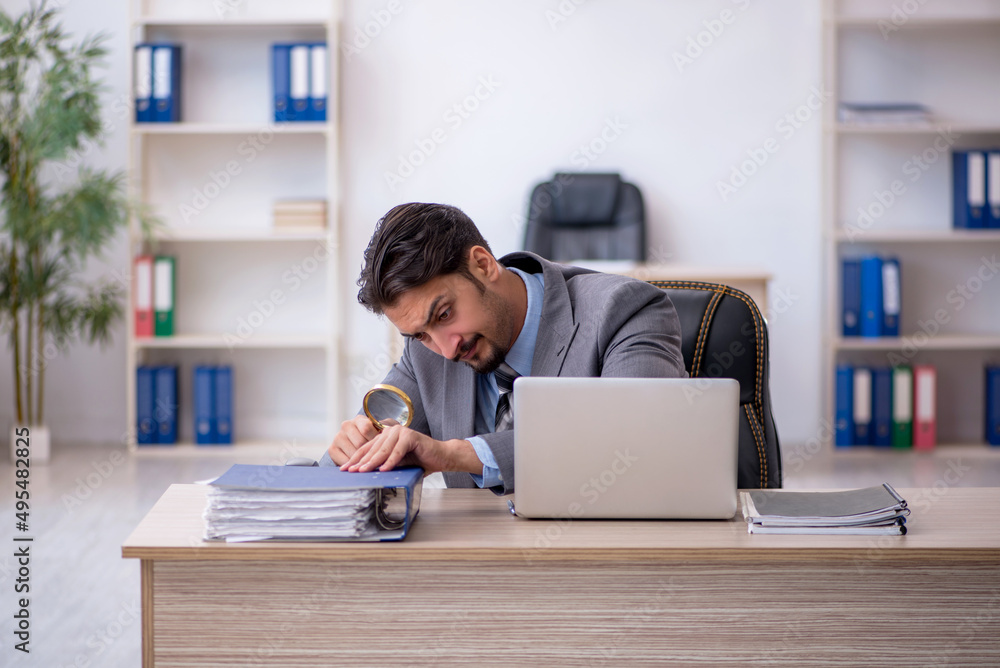 Young male employee working in the office Young male employee working in the office