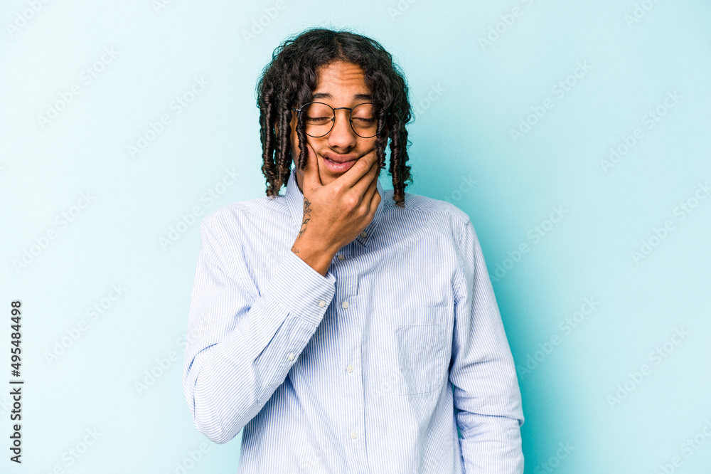 Young African American man isolated on blue background having a strong teeth pain, molar ache. Young African American man isolated on blue background having a strong teeth pain, molar ache.