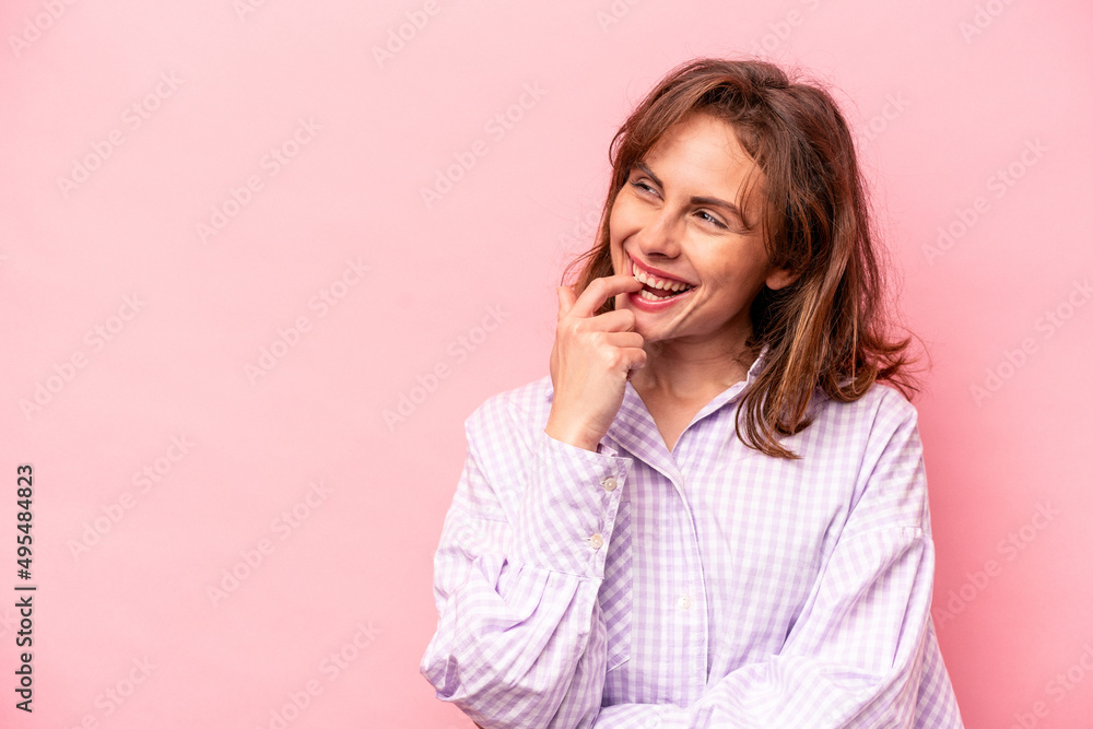 Young caucasian woman isolated on pink background relaxed thinking about something looking at a copy space. Young caucasian woman isolated on pink background relaxed thinking about something looking at a copy space.