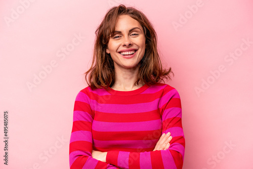 Young caucasian woman isolated on pink background who feels confident, crossing arms with determination. © Asier