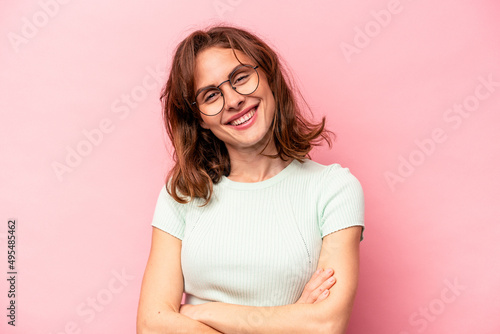 Young caucasian woman isolated on pink background who feels confident, crossing arms with determination.