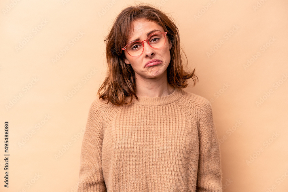 Young caucasian woman isolated on beige background sad, serious face, feeling miserable and displeased. Young caucasian woman isolated on beige background sad, serious face, feeling miserable and displeased.