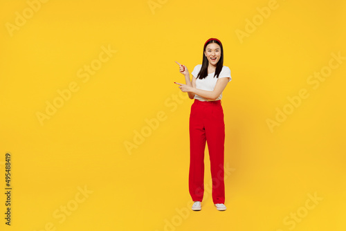 Full size body length promoter young girl woman of Asian ethnicity 20s years old in casual clothes point aside on workspace area copy space mock up isolated on plain yellow background studio portrait. photo