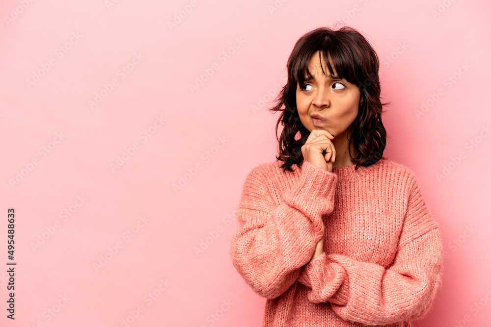 Young hispanic woman isolated on pink background looking sideways with doubtful and skeptical expression. Young hispanic woman isolated on pink background looking sideways with doubtful and skeptical expression.