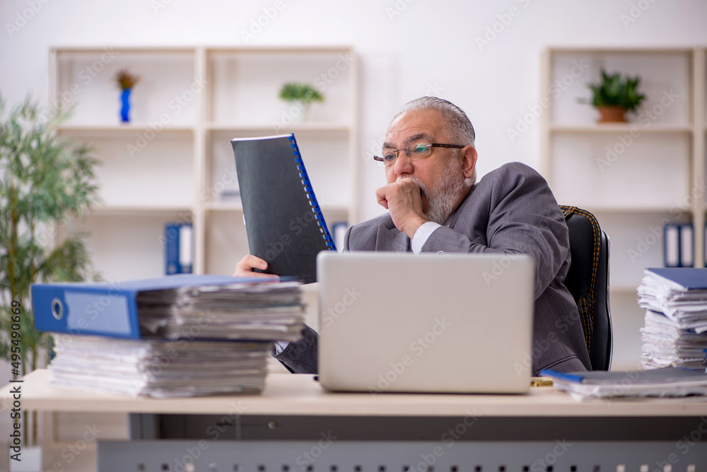 Old male employee and too much work in the office Old male employee and too much work in the office